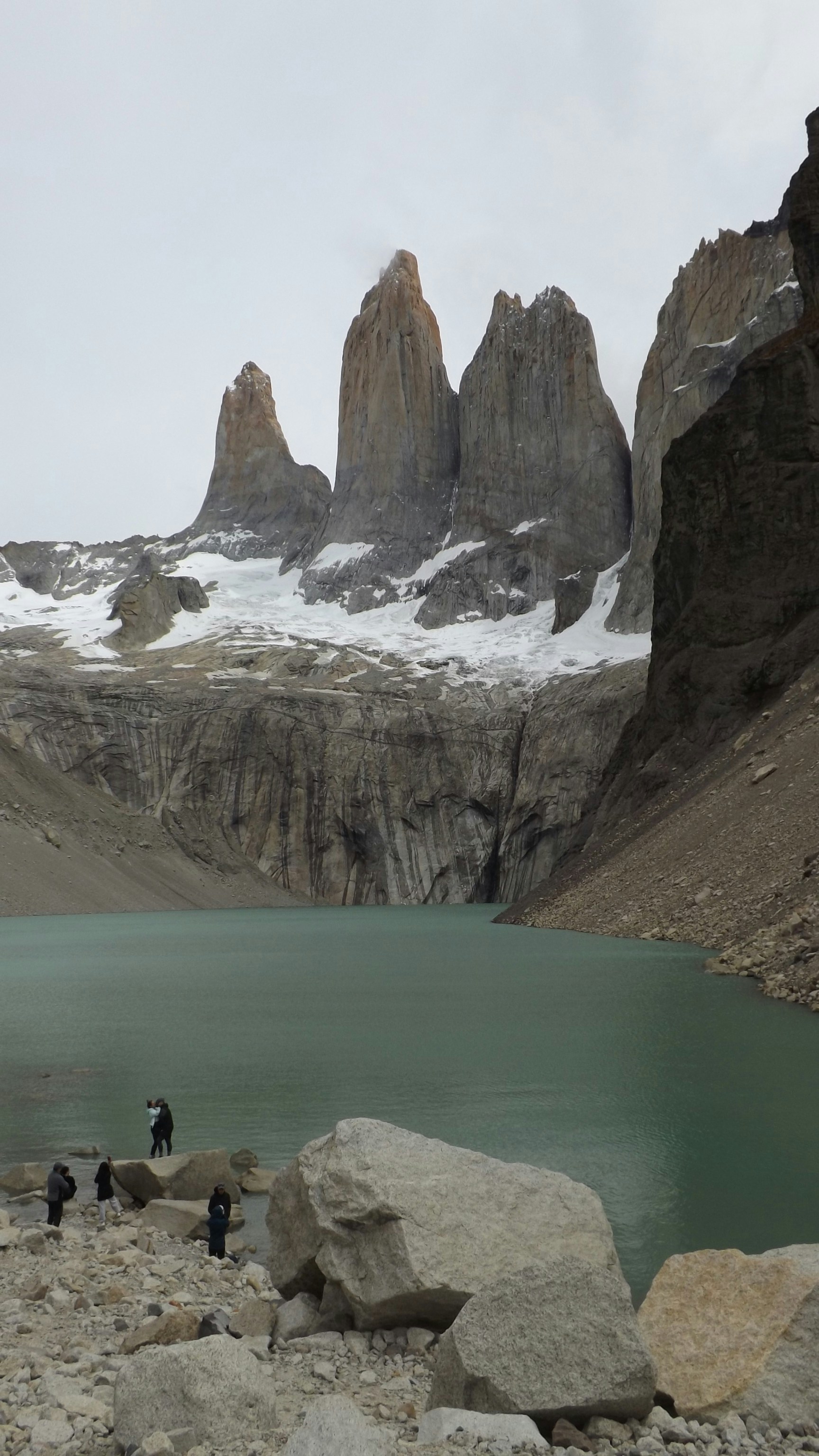 a group of people standing next to a mountain lake