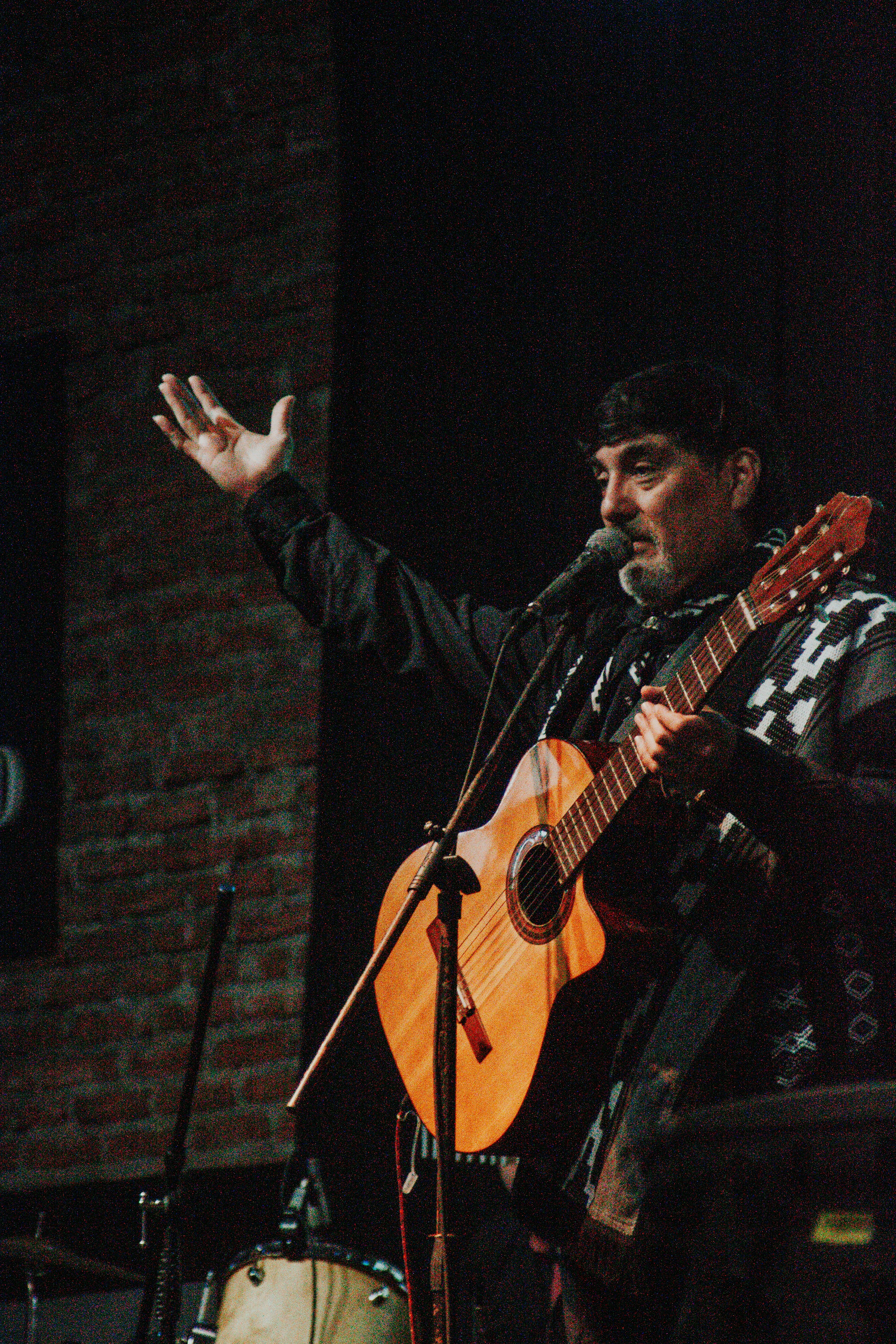 FAQ: Your Burning Questions About Chilean Musicians Answered by Chile Vacay a man holding a guitar while standing next to a microphone
