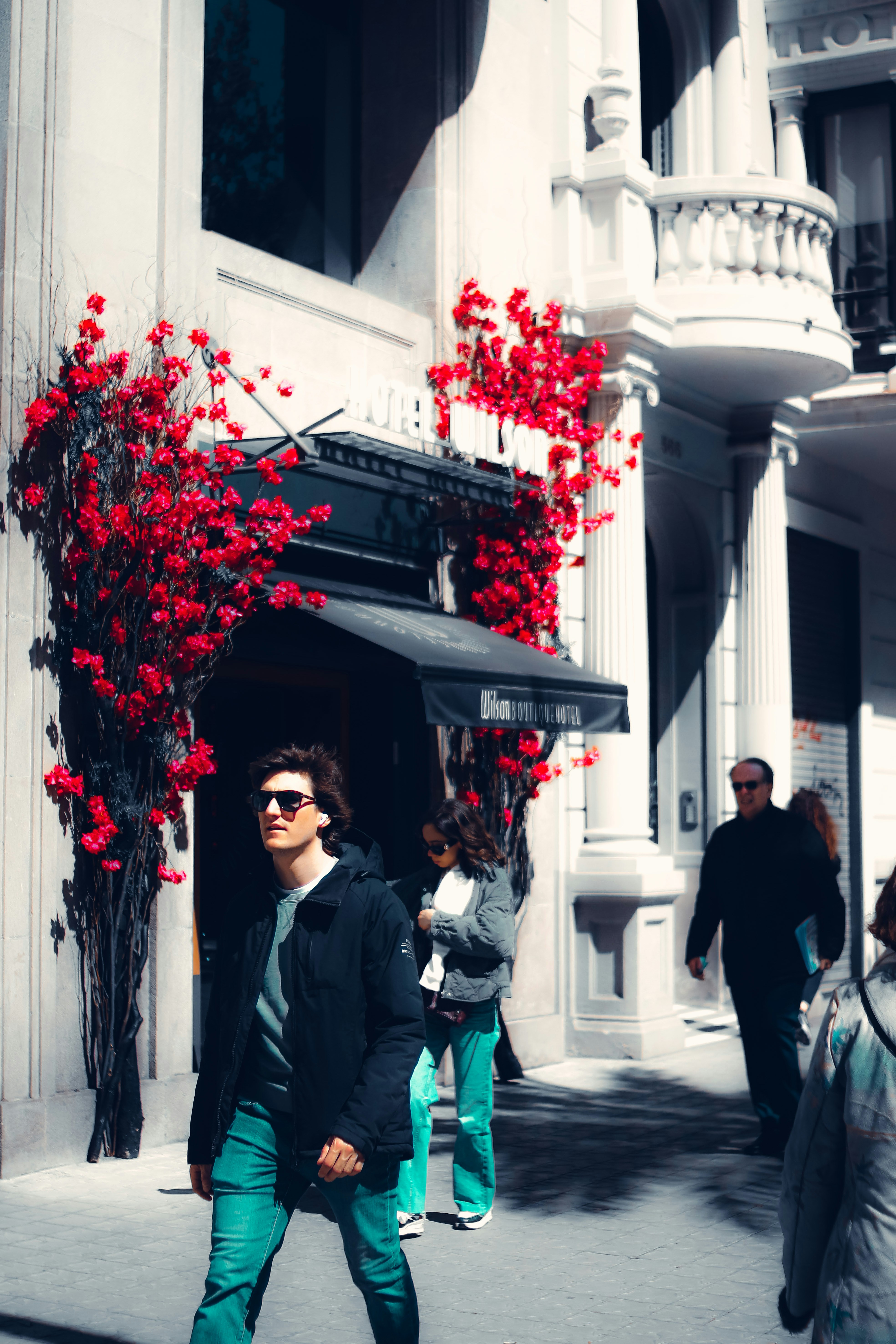 a man walking down a street next to a building