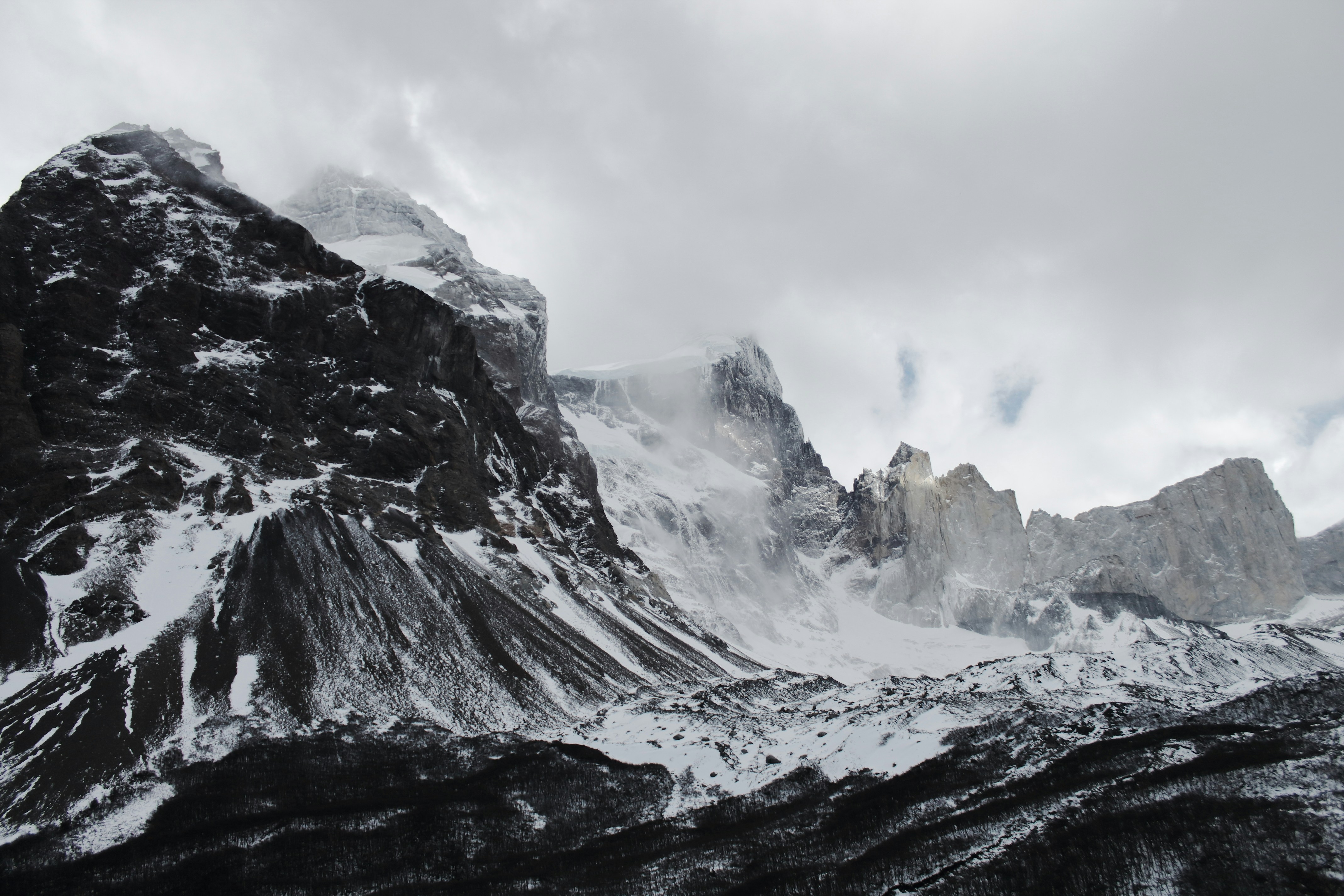 a snowy mountain with clouds