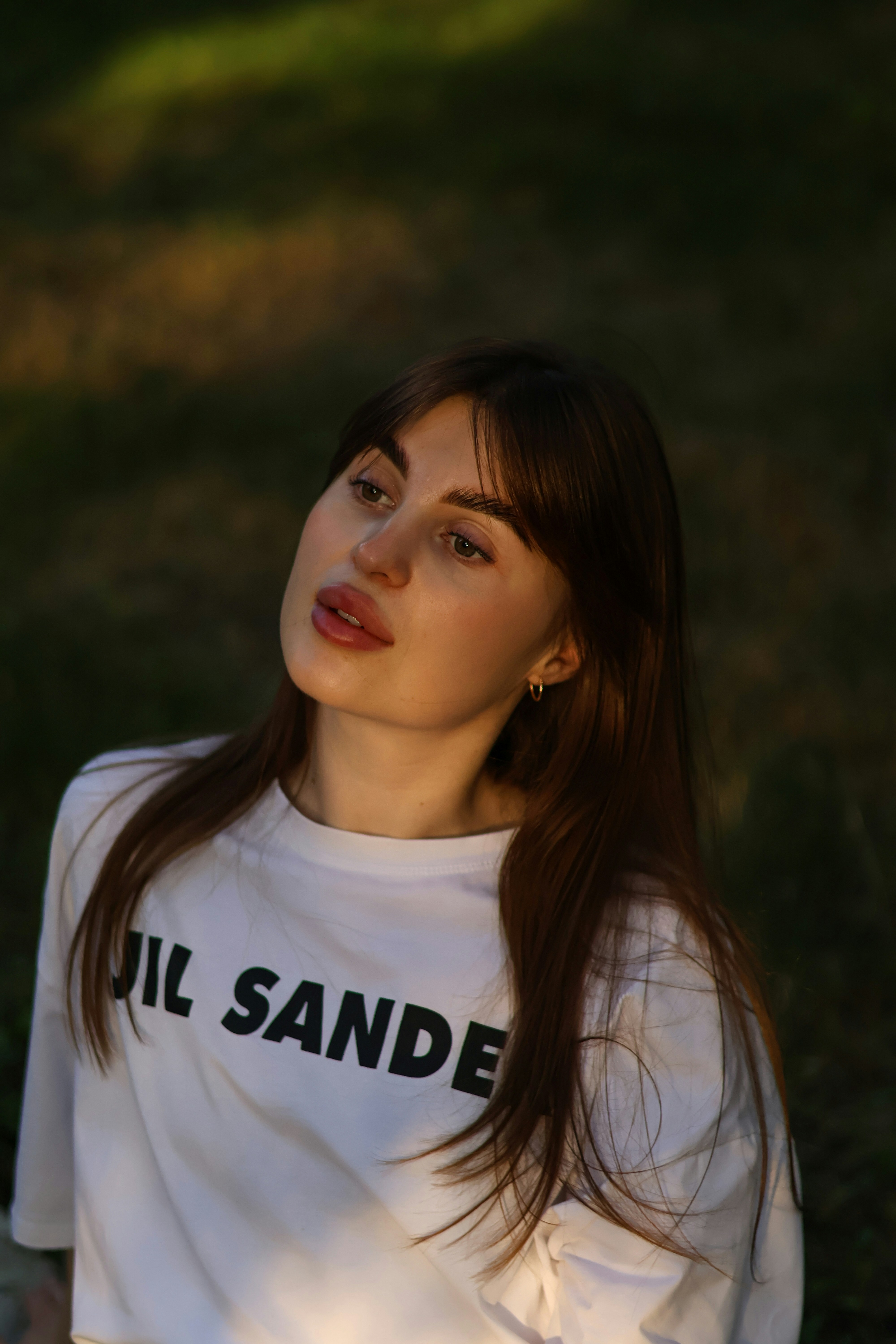 a woman with long brown hair wearing a white shirt