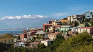 Editorial image of colorful Chilean hillside homes with an Andean backdrop for a culture, history, and adventure travel guide.